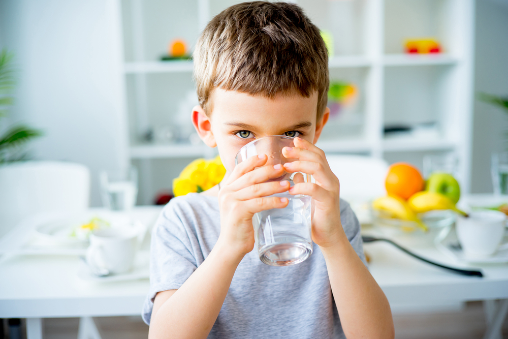 kid drinks water and looking into camera