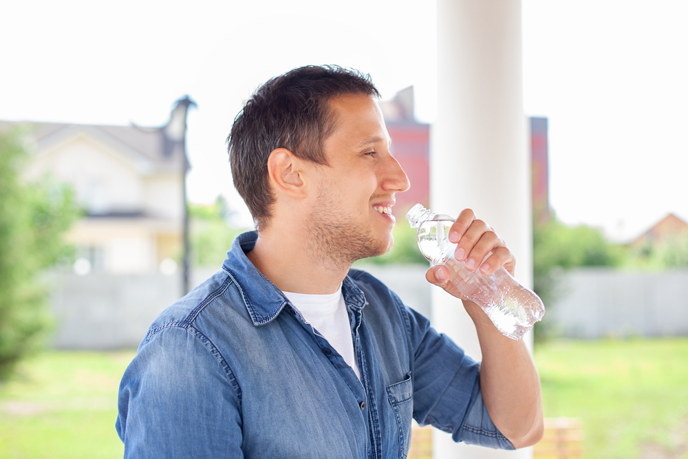 close up of young man drinking water outdoor